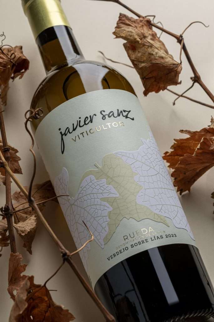Botella de Javier Sanz Verdejo entre sarmientos y hojas secas de vid